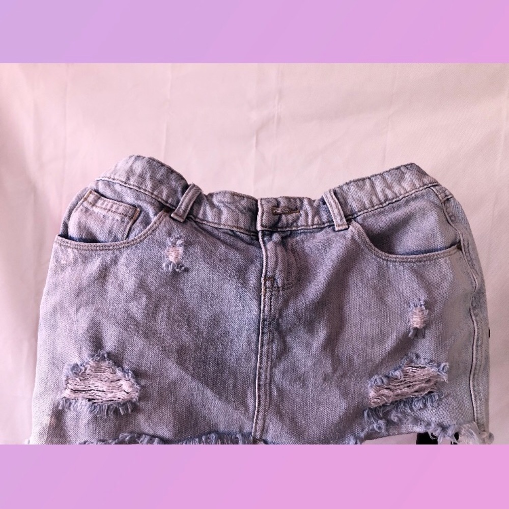 Light wash 5 pocket distressed denim skirt .